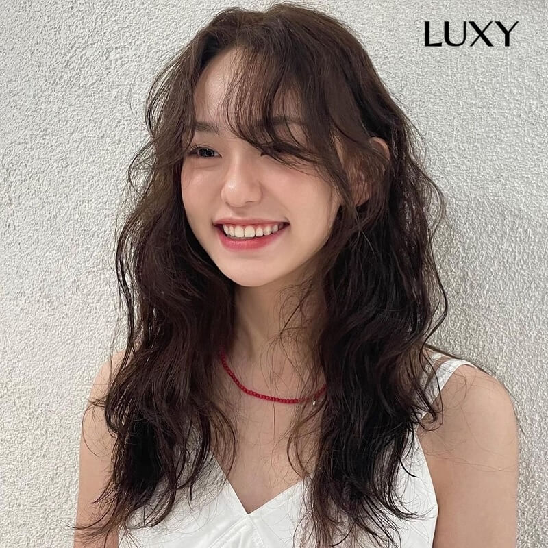 Tóc uốn xoăn nhẹ mái thưa cho khuôn mặt dài và gầy